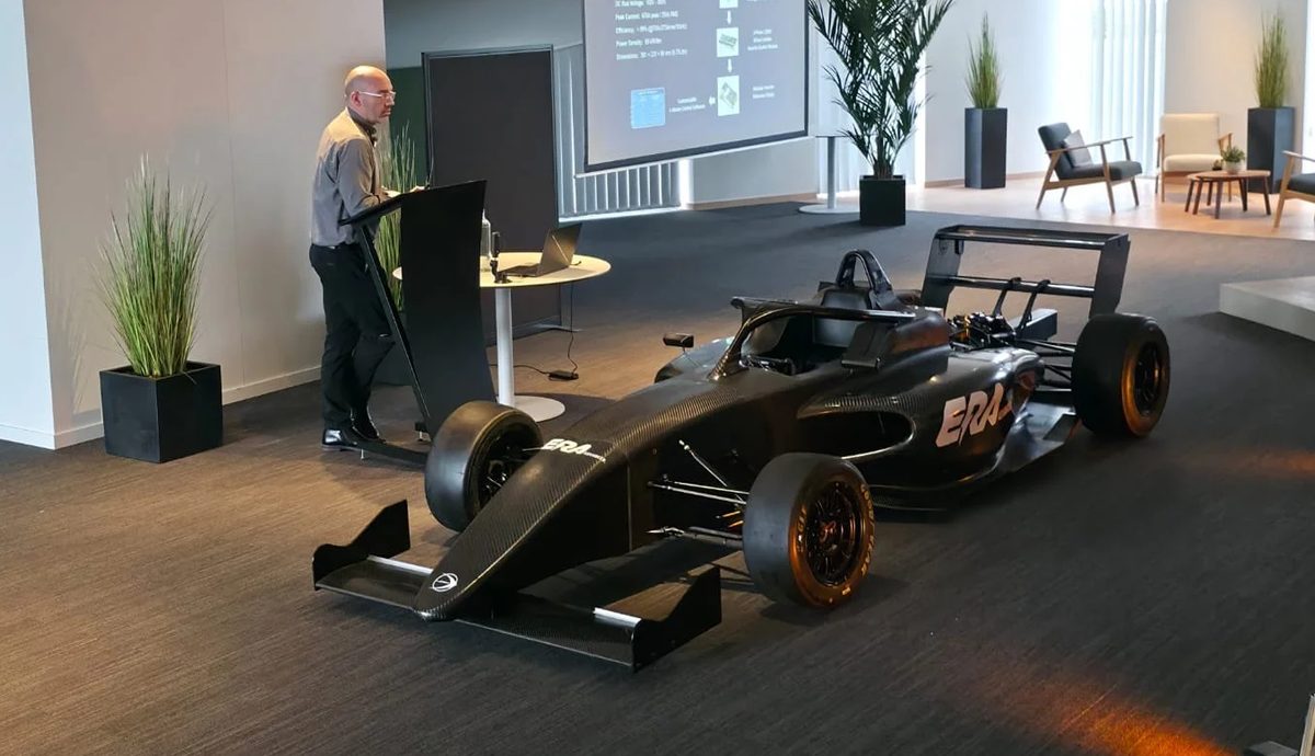 Dieter presenting the launch of the second-generation ERA Advanced ARC4, the car displayed in bare carbon fibre beside him.