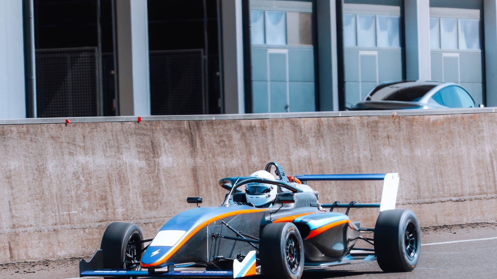 The ARC4 Formula 4 electric car in the pit lane during a track test.